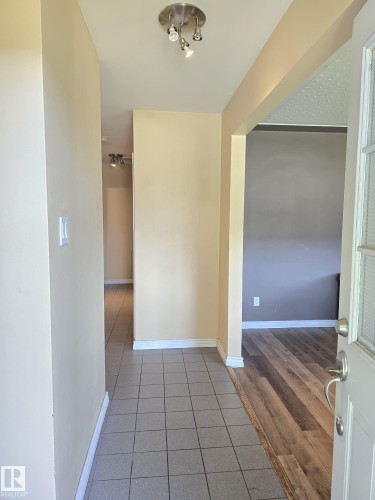 Entryway featuring square tile flooring, a track light fixture, and a light-colored wall palette - 9616 63 Avenue, Edmonton, AB 