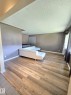 Spacious interior featuring wood-finish flooring, neutral wall tones, and recessed lighting - 9616 63 Avenue, Edmonton, AB 
