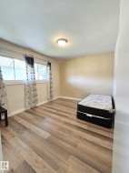 Room featuring wood-finish flooring, neutral wall tones, and overhead lighting - 
