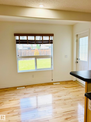 Hardwood flooring throughout, recessed ceiling lighting, and a window with a woven wood shade - 3120 25 Avenue, Edmonton, AB 