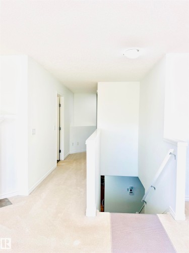 Second-story landing featuring neutral carpet flooring, white painted walls, and a recessed ceiling light fixture - 3120 25 Avenue, Edmonton, AB 