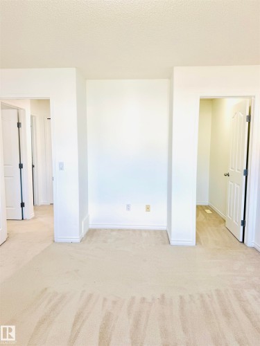Neutral-toned wall-to-wall carpeting throughout, complemented by crisp white baseboards - 3120 25 Avenue, Edmonton, AB 