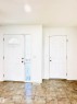 Foyer featuring neutral-toned tile flooring, white interior walls, and two white paneled doors - 3120 25 Avenue, Edmonton, AB 