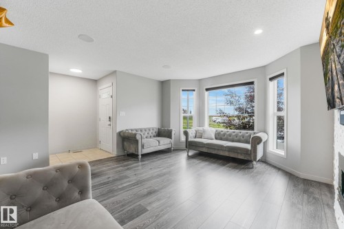 Bright living area featuring wood-finish flooring, recessed lighting, and a bay window with multiple panes - 17724 58 Street Nw, Edmonton, AB 