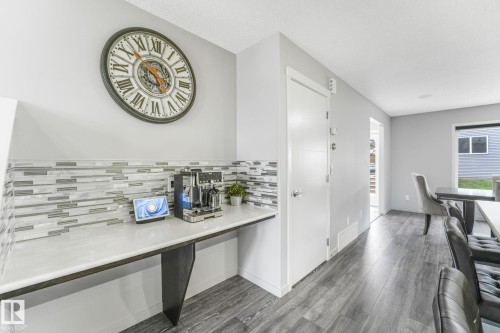 Built-in countertop with a quartz surface and a multi-tone linear tile backsplash - 17724 58 Street Nw, Edmonton, AB 
