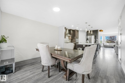 Open-concept living space featuring wood-finish flooring, recessed lighting, and a modern kitchen - 17724 58 Street Nw, Edmonton, AB 