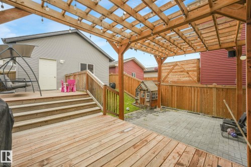 Expansive multi-level wood deck featuring a pergola with string lighting - 17724 58 Street Nw, Edmonton, AB 