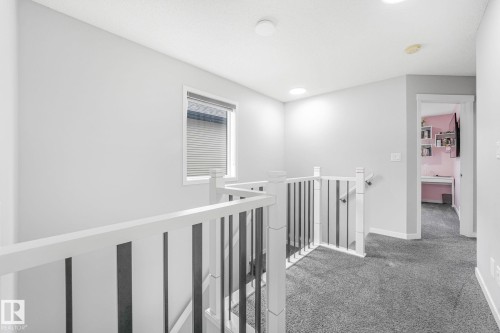 Upper-level landing featuring light gray walls and dark gray carpeting - 17724 58 Street Nw, Edmonton, AB 