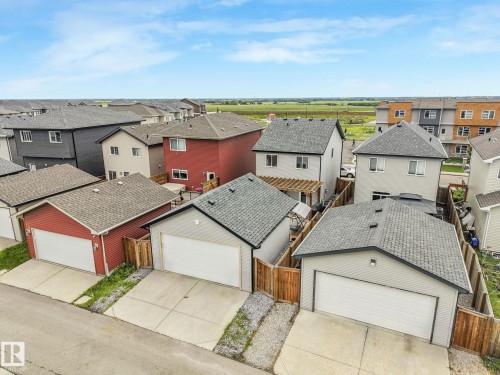Detached garage with a white overhead door, concrete driveway, and wood fencing - 17724 58 Street Nw, Edmonton, AB 