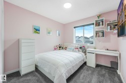 Bedroom featuring plush gray carpeting, a large window, and built-in floating shelves - 