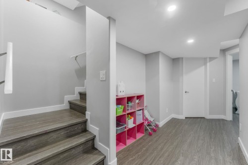 Lower level featuring wood-finish flooring, recessed lighting, and a white interior door with contemporary hardware - 17724 58 Street Nw, Edmonton, AB 