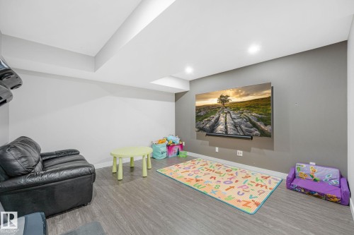 Spacious recreation area featuring wood-finish flooring and recessed lighting - 17724 58 Street Nw, Edmonton, AB 
