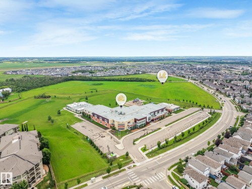 Aerial perspective showcasing a community with residential properties, institutional buildings, roads, and green spaces - 17724 58 Street Nw, Edmonton, AB 
