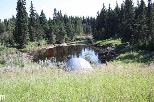 Natural water feature bordered by mature evergreen trees - Rr202 Twp583, Rural Thorhild County, AB 