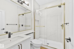 Contemporary bathroom featuring a frameless glass shower with gold-tone hardware, white marble-look shower walls, a built-in shower niche, and a white vanity with a quartz countertop - 