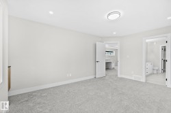 Spacious room featuring light gray carpeting, recessed lighting, and a contemporary flush-mount ceiling fixture - 