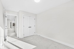 Carpeted room with white walls, a flush-mount ceiling light, and white baseboards - 