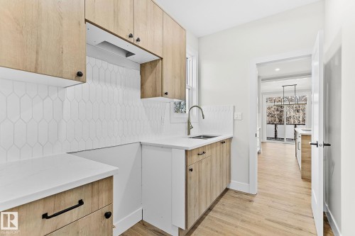 Kitchen featuring wood-finish cabinetry, white countertops, and a white picket tile backsplash - 204 Falcon Crescent, Leduc, AB 