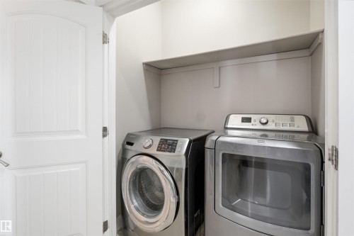 Dedicated laundry area featuring a built-in shelf for storage and a paneled interior door - 16807 54 Street, Edmonton, AB - Indoor Photo Showing Laundry Room