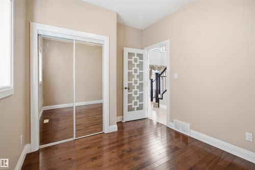 Interior room featuring wood-finish flooring, light-toned wall paint, and white baseboards - 16807 54 Street, Edmonton, AB - Indoor Photo Showing Other Room