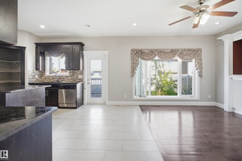 Spacious open-concept living area featuring a large window with decorative valance, recessed lighting, and a ceiling fan - 16807 54 Street, Edmonton, AB - Indoor Photo Showing Other Room With Fireplace