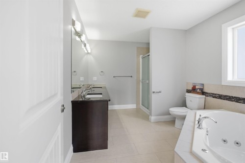 Spacious bathroom featuring a dual vanity with dark cabinetry and a polished countertop - 16807 54 Street, Edmonton, AB - Indoor Photo Showing Bathroom