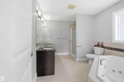 Spacious bathroom featuring a dual vanity with dark cabinetry and a polished countertop - 