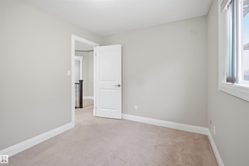 Interior room featuring light gray walls, white trim, and neutral carpeting - 16807 54 Street, Edmonton, AB - Indoor Photo Showing Other Room