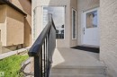 Front entrance with a concrete porch and steps, featuring a white door with decorative glass inserts - 16807 54 Street, Edmonton, AB  - Outdoor With Exterior 
