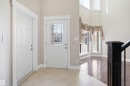 Foyer with decorative leaded glass front door, tile flooring, rich wood-finish flooring, and a dark wood banister - 16807 54 Street, Edmonton, AB  - Indoor Photo Showing Other Room 