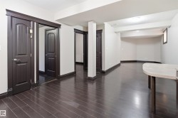 Spacious interior featuring dark wood-finish flooring, white walls, and dark trim throughout - 