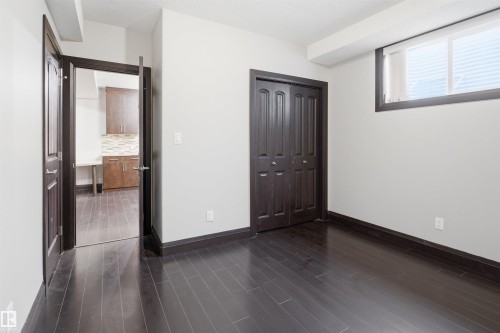 Room featuring dark wood-finish flooring, white walls, and dark trim - 16807 54 Street, Edmonton, AB - Indoor Photo Showing Other Room