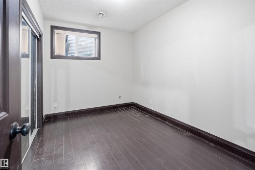 Room featuring dark wood-finish flooring, white walls, and dark trim - 16807 54 Street, Edmonton, AB - Indoor Photo Showing Other Room
