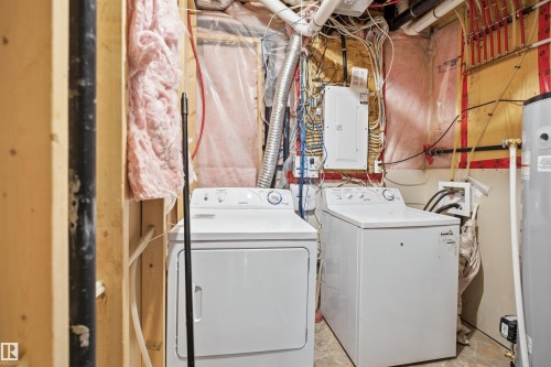 Utility area featuring laundry appliances, water heater, and exposed mechanicals - 16807 54 Street, Edmonton, AB - Indoor Photo Showing Laundry Room