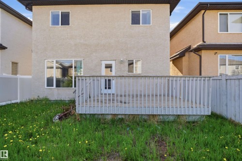 Rear exterior featuring a wooden deck with railing, stucco siding, and a back door with glass paneling - 16807 54 Street, Edmonton, AB - Outdoor With Exterior