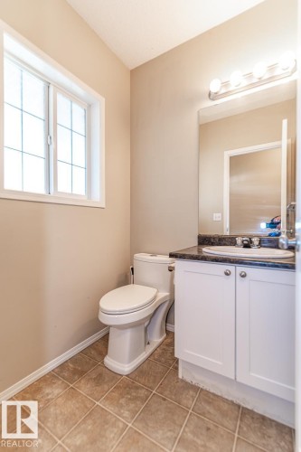 White vanity with a dark countertop and undermount sink - 39 Vega Avenue, Spruce Grove, AB - Indoor Photo Showing Bathroom