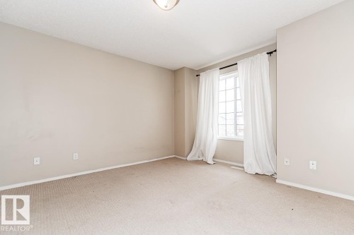 Carpeted room with a multi-pane window, neutral wall tones, white trim, and an overhead flush mount light fixture - 39 Vega Avenue, Spruce Grove, AB - Indoor Photo Showing Other Room