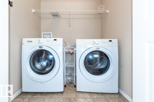 Dedicated laundry area featuring tile-finish flooring and a white wire shelving unit for storage - 39 Vega Avenue, Spruce Grove, AB - Indoor Photo Showing Laundry Room