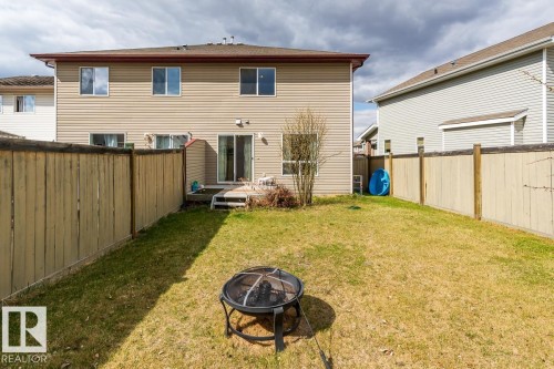 Private backyard featuring a wooden privacy fence, a ground-level deck, and a two-story exterior with horizontal siding - 39 Vega Avenue, Spruce Grove, AB - Outdoor With Exterior