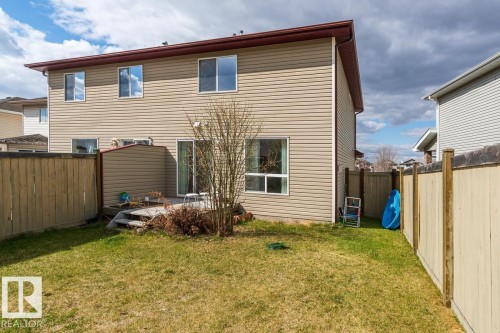 Expansive rear yard featuring a wooden privacy fence, a ground-level wood deck, and a sliding glass door entry - 39 Vega Avenue, Spruce Grove, AB - Outdoor With Exterior