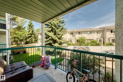 Private balcony featuring a green metal railing and textured stucco exterior - #208 9619 174 St Nw, Edmonton, AB 