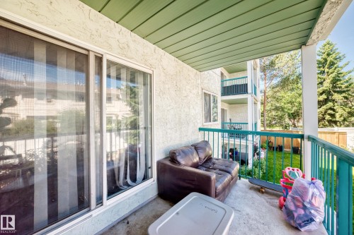 Private balcony with concrete flooring, green metal railings, and a green soffit - #208 9619 174 St Nw, Edmonton, AB 
