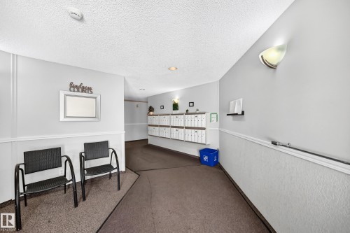 Mailbox stations within a communal hallway featuring textured wall paneling and a carpeted floor - #208 9619 174 St Nw, Edmonton, AB 