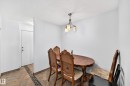 Dining area featuring neutral wall tones, tile flooring with a decorative inlay, and a ceiling-mounted light fixture - #208 9619 174 St Nw, Edmonton, AB 
