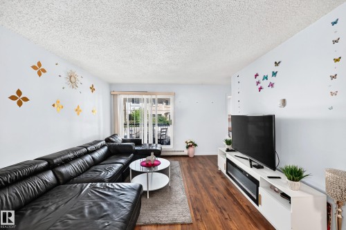 Expansive living area featuring warm wood-finish flooring - #208 9619 174 St Nw, Edmonton, AB 