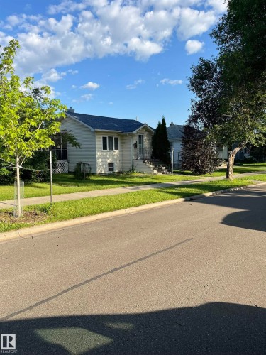 Cream-colored siding residence featuring a dark blue roof and white trim - 11938 70 Nw, Edmonton, AB 