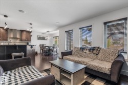 Open-concept living space featuring wood-finish flooring, recessed lighting, a kitchen island, and a dining area - 
