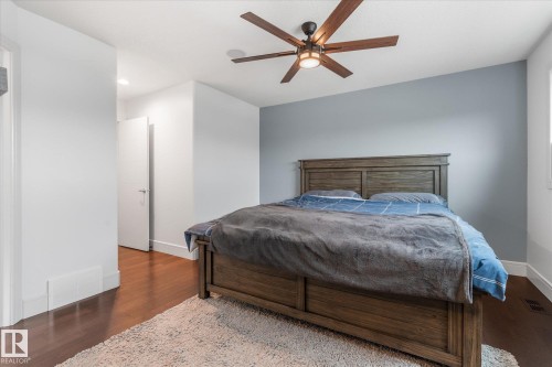 Bedroom featuring wood-finish flooring, a contemporary ceiling fan with integrated lighting, recessed lighting, white trim, and a window - 6 Sedona Place, Fort Saskatchewan, AB - Indoor Photo Showing Bedroom