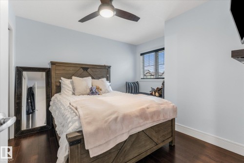 Bedroom with rich wood-finish flooring and a contemporary ceiling fan - 6 Sedona Place, Fort Saskatchewan, AB - Indoor Photo Showing Bedroom