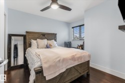 Bedroom with rich wood-finish flooring and a contemporary ceiling fan - 